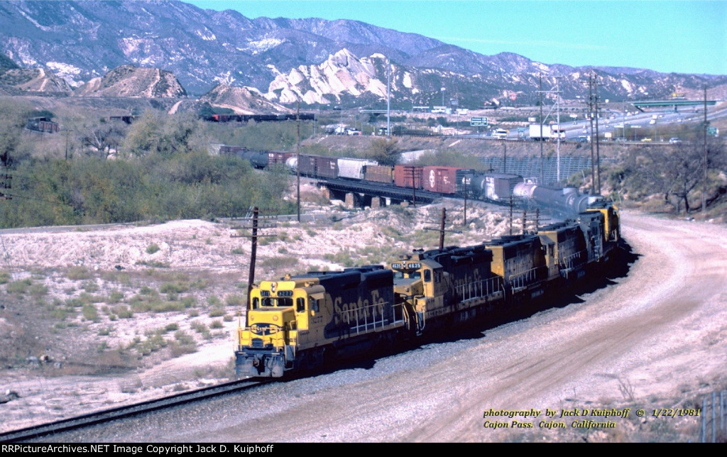 AT&SF, Santa FE GP30 3277 leads a westbound freight, with five other units, down Cajon Pass, Cajon, California. January 22, 1981. 